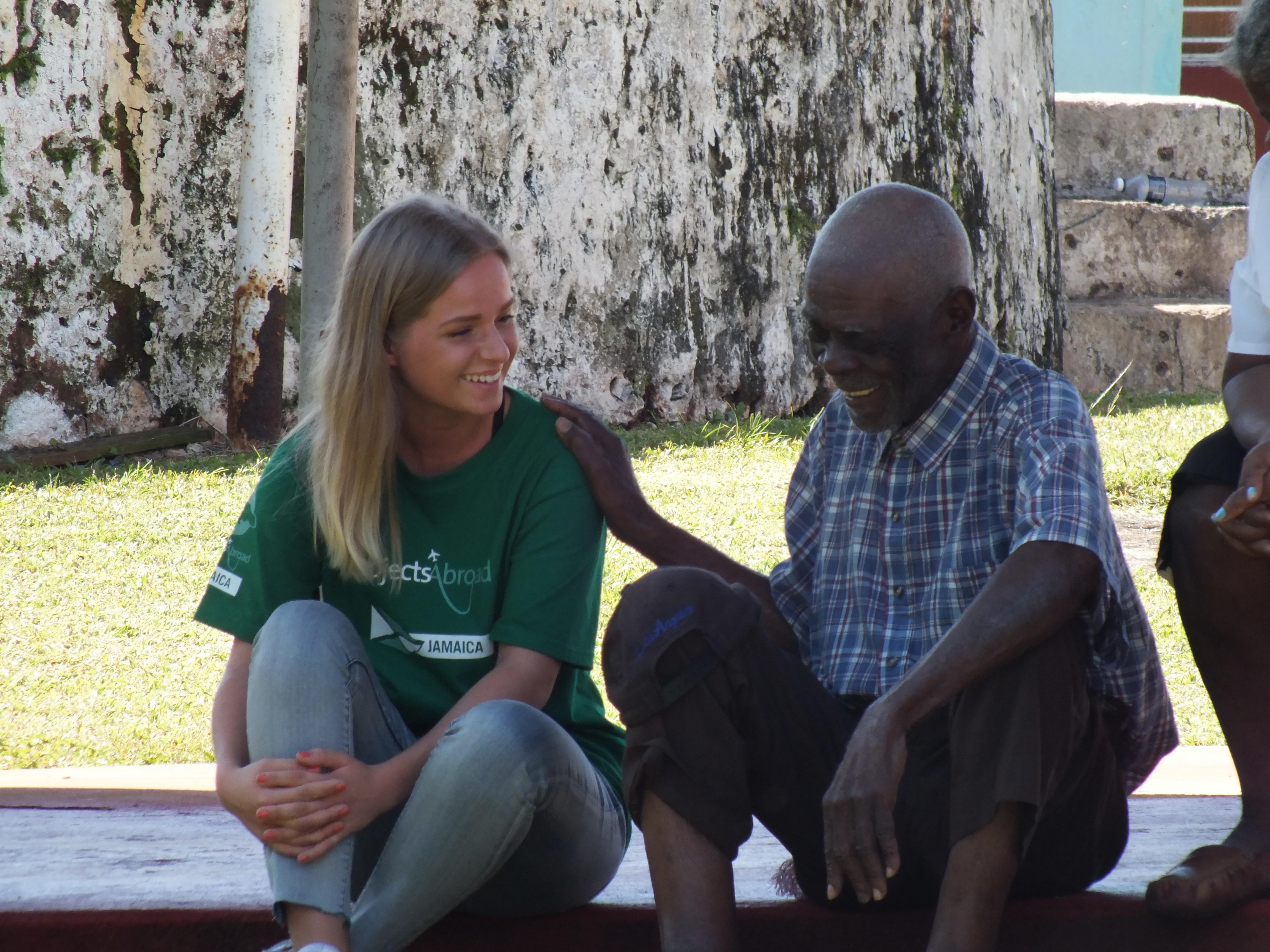 A female Care and Psychology worker talks to a local man during a Community Outreach Day in Jamaica. Projects Abroad Care volunteer speaks to a local man within the Community Outreach Day during Psychology placements in Jamaica.